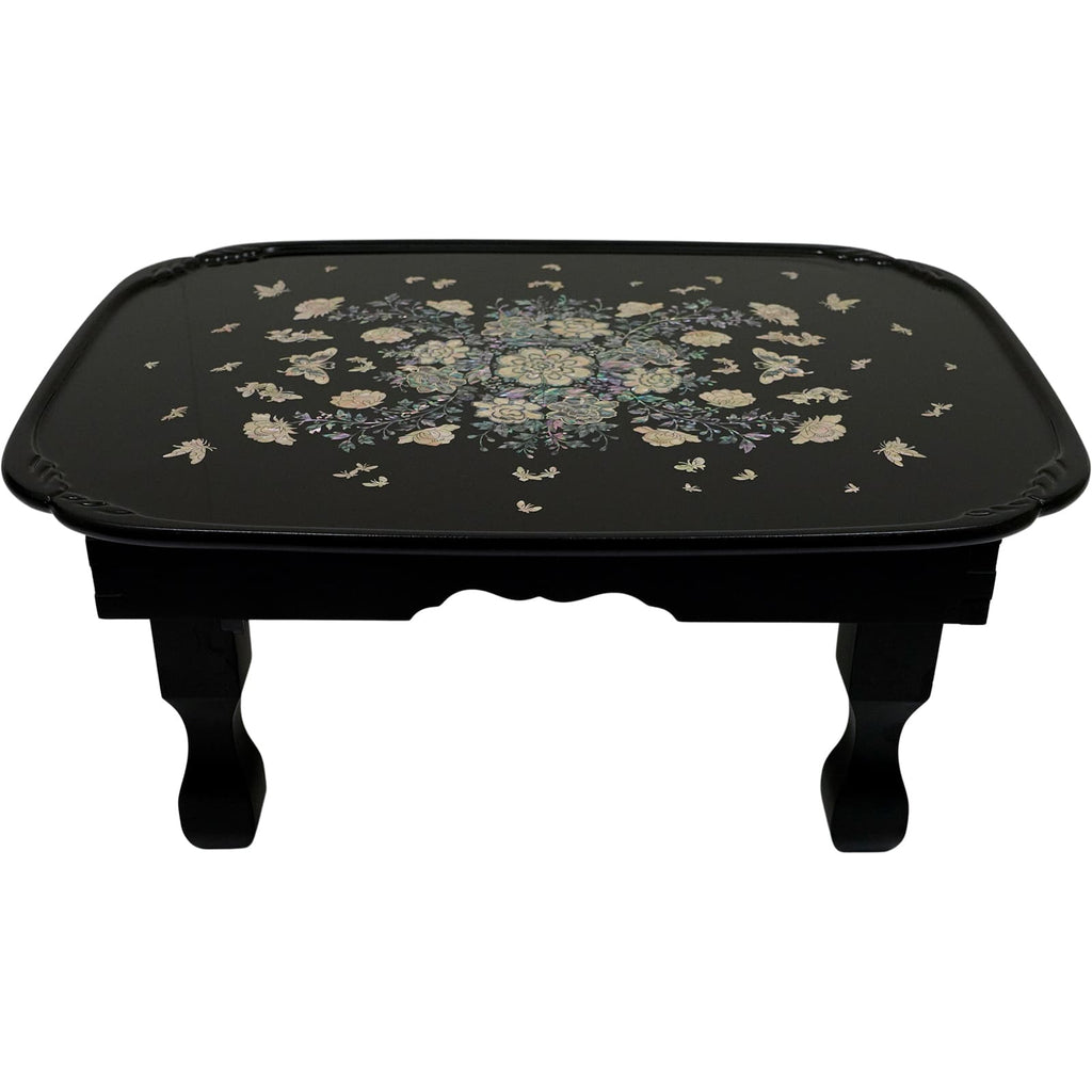 Black table with a floral mother-of-pearl top.