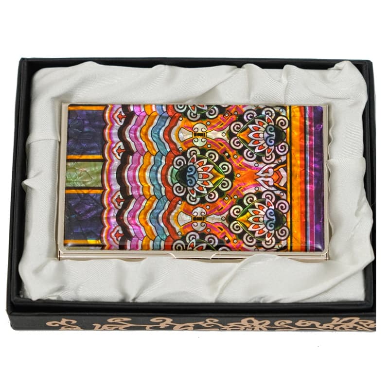 This image shows a vibrant, multicolored mother of pearl business card holder with a paisley and wavy stripe design, presented in an elegant black box with white satin lining.