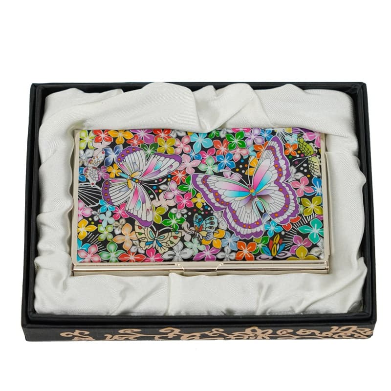 A vibrant business card case adorned with a colorful mother-of-pearl butterfly and floral design, presented in a black box with white satin lining.
