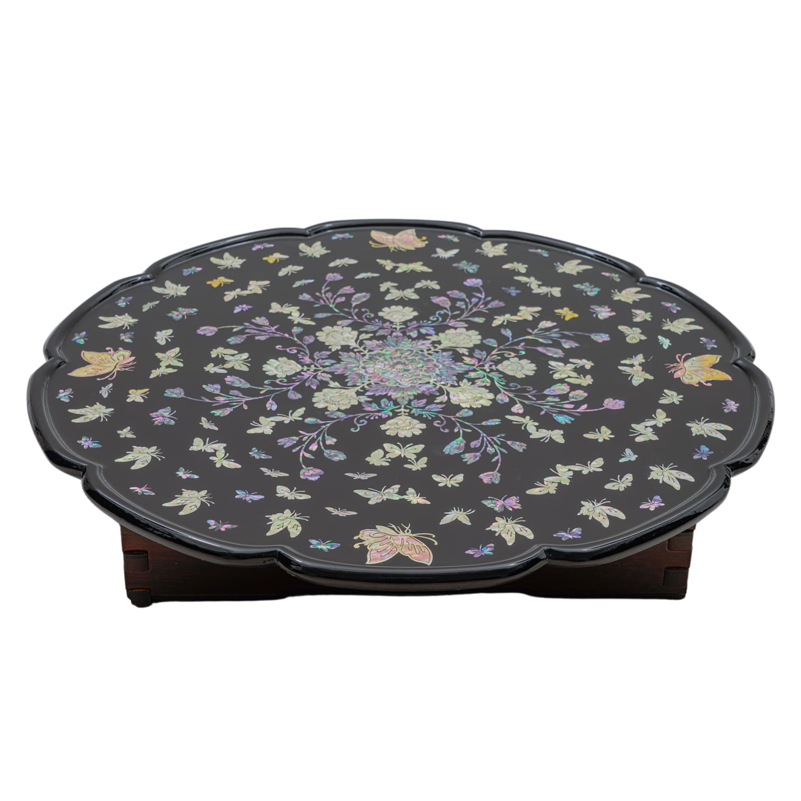 Black round table with scalloped edges, featuring intricate mother-of-pearl inlay of flowers and butterflies