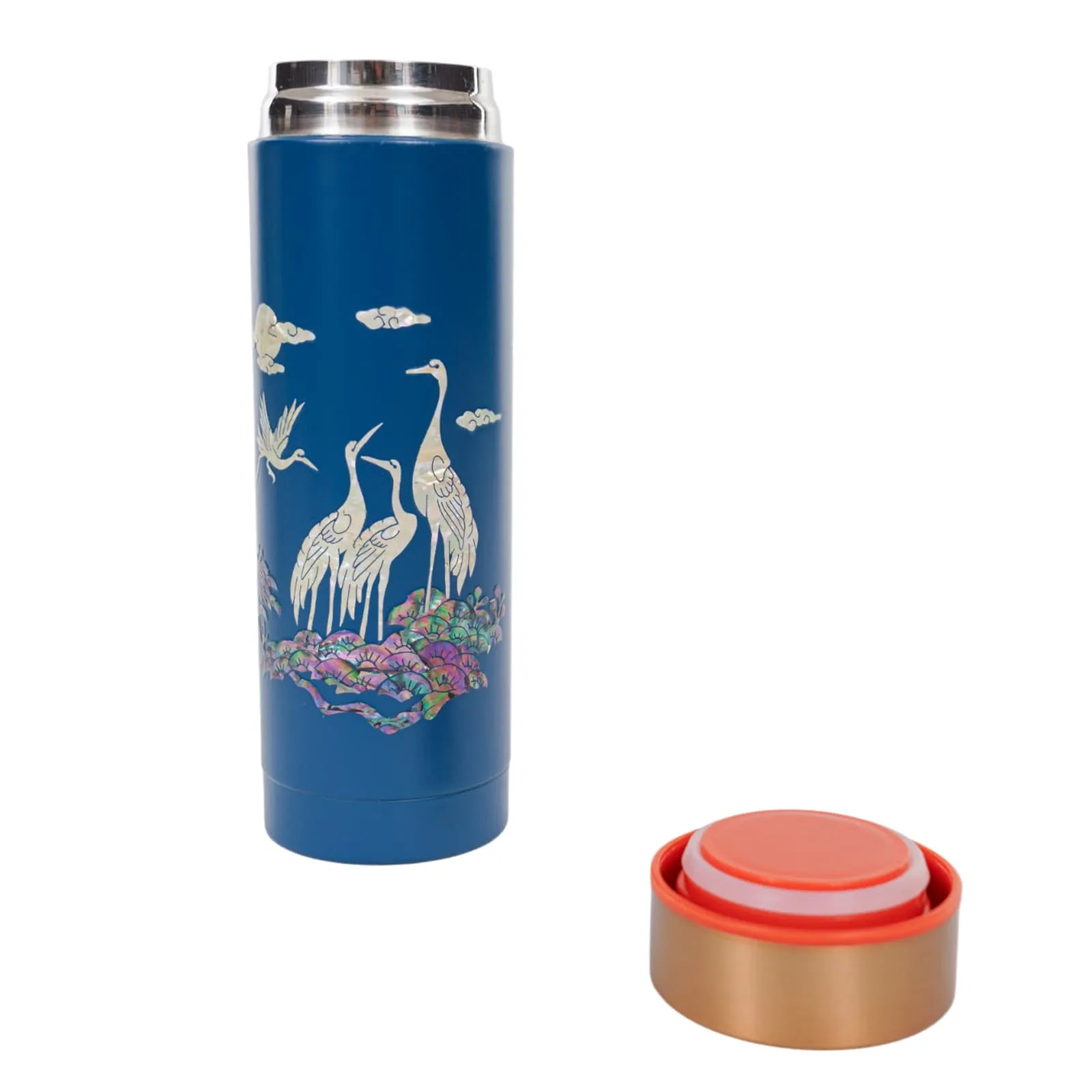 Blue tumbler with mother-of-pearl cranes and open gold-orange lid beside it