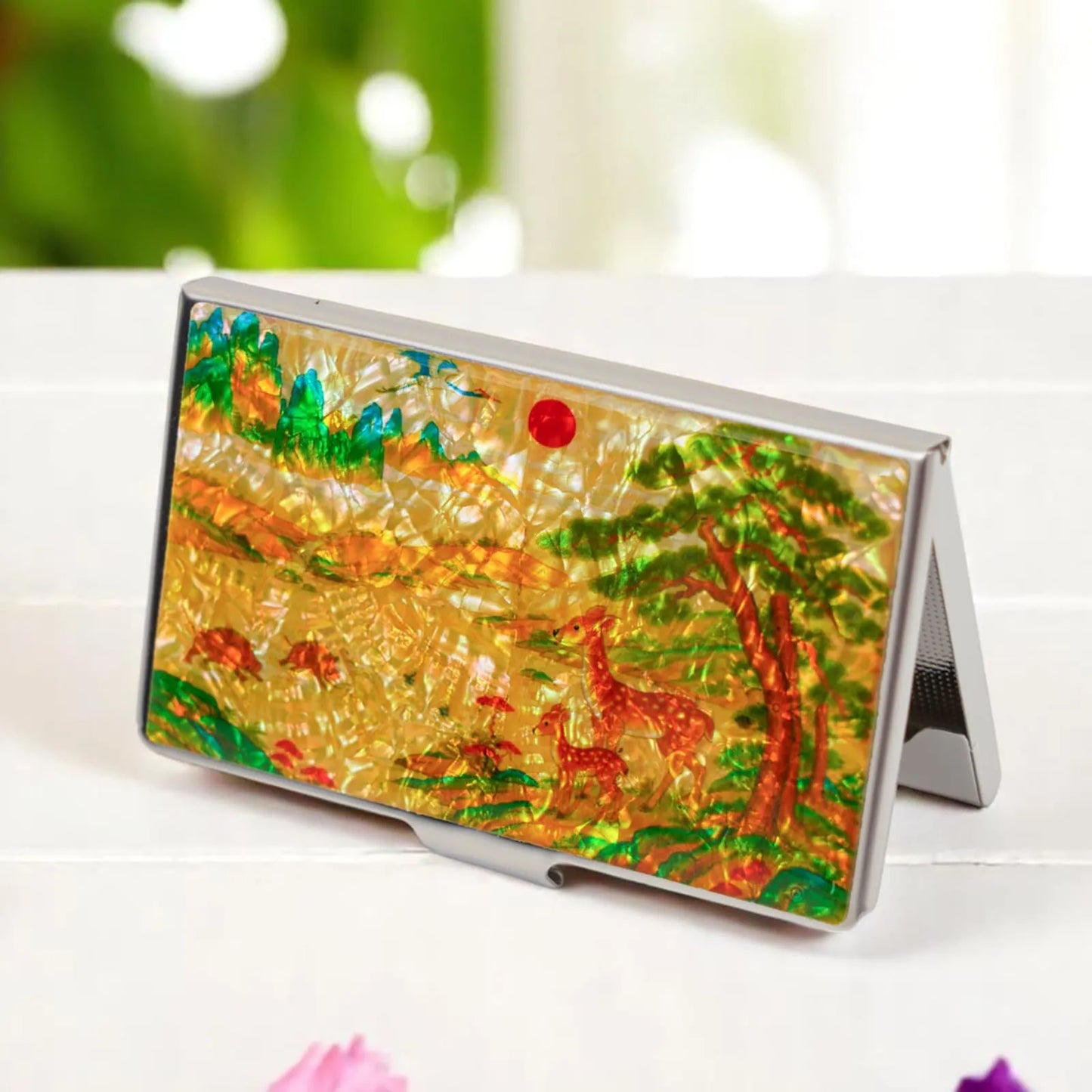 Colorful mother-of-pearl card holder standing open on a white table