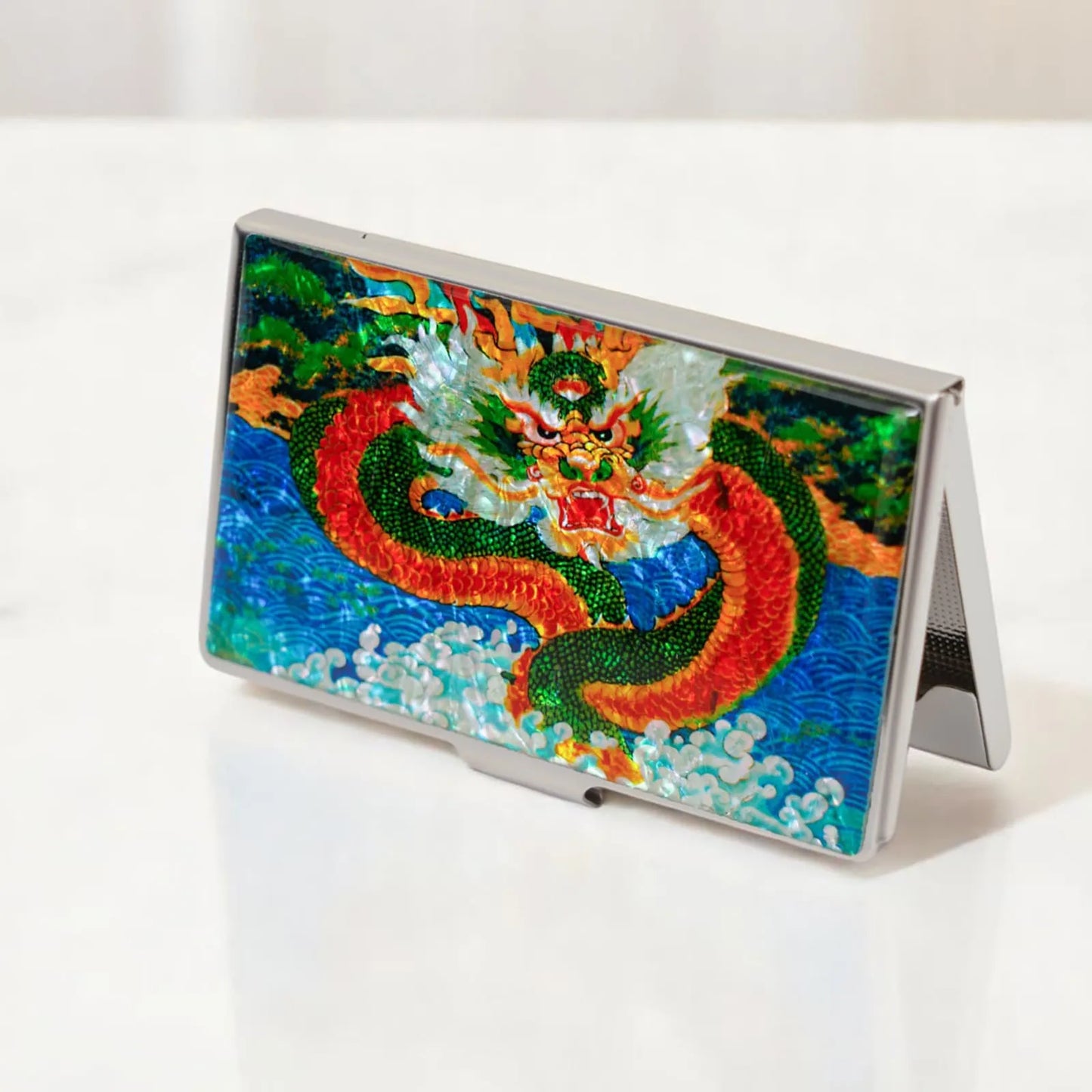Dragon design card case standing upright on a white marble surface