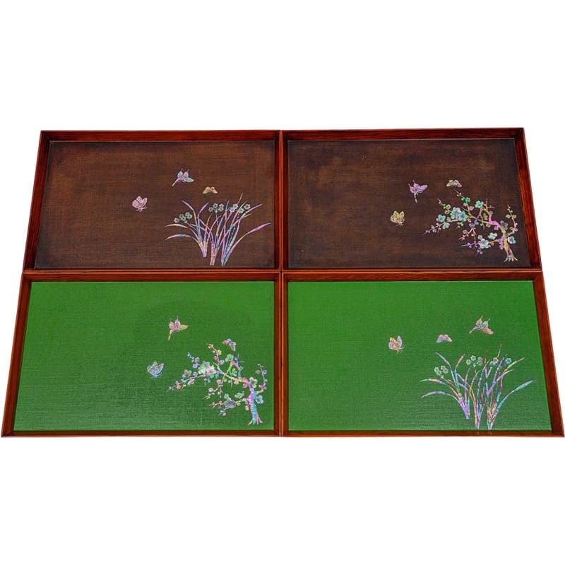 Four square trays arranged together, two with a green base and two with a wood base, all featuring mother-of-pearl inlays of various plants and butterflies.