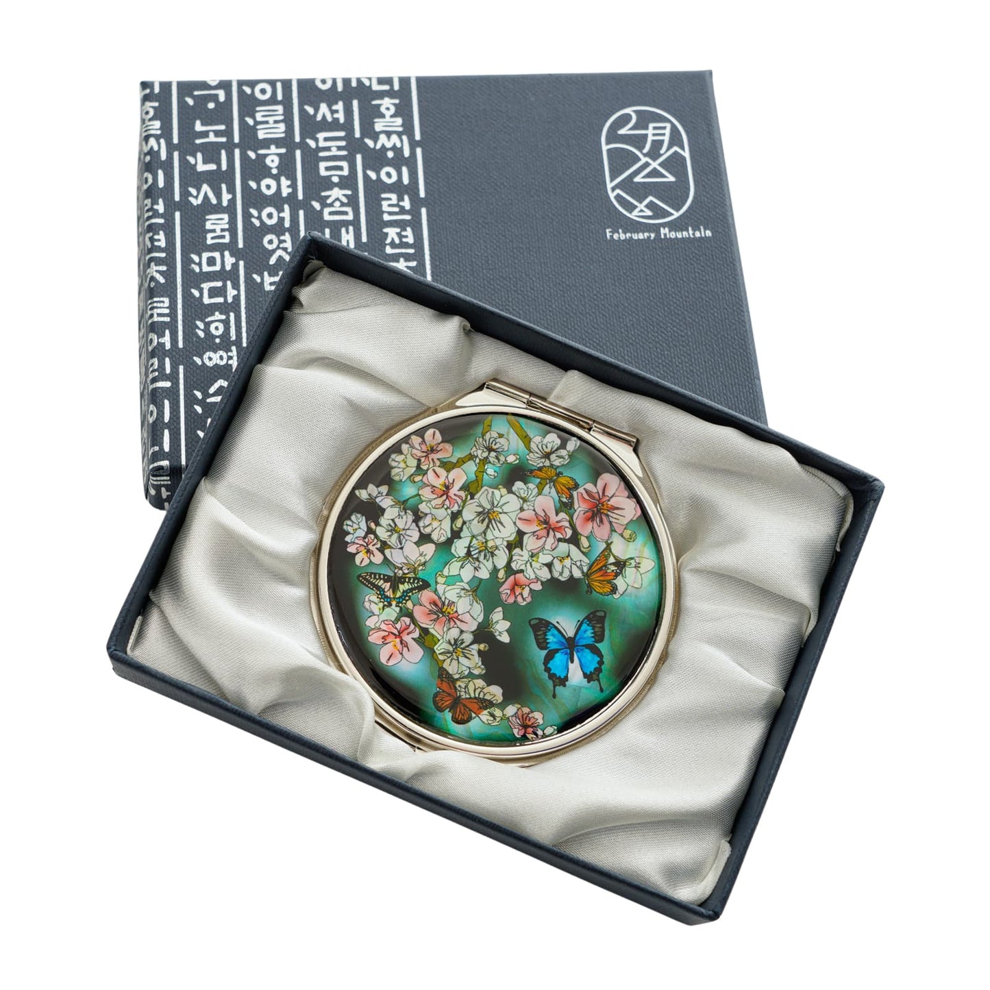Luxury compact mirror featuring blooming flowers and vibrant butterflies on a green background, elegantly boxed for gifting