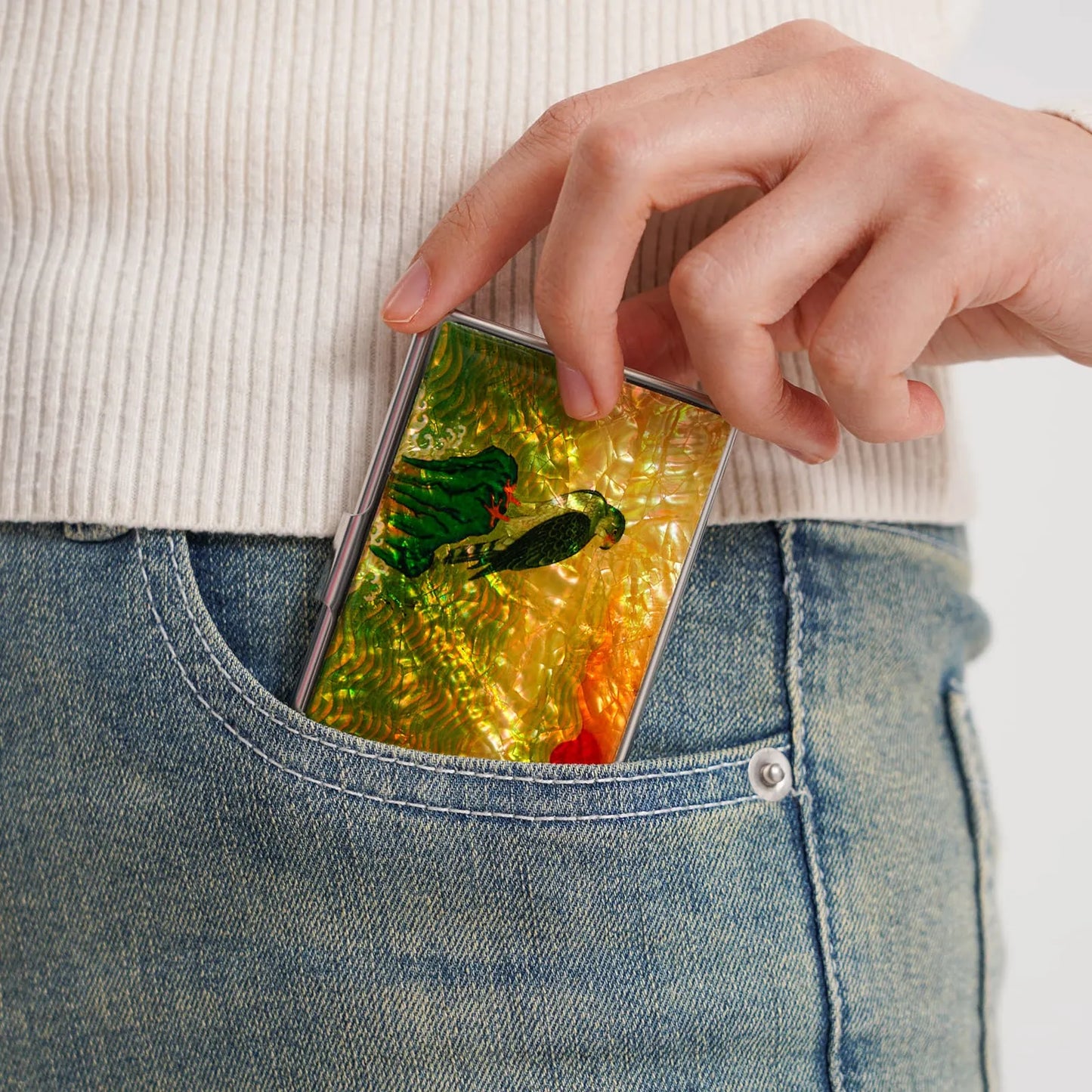 Pocket-sized falcon mother-of-pearl card case sliding into jeans