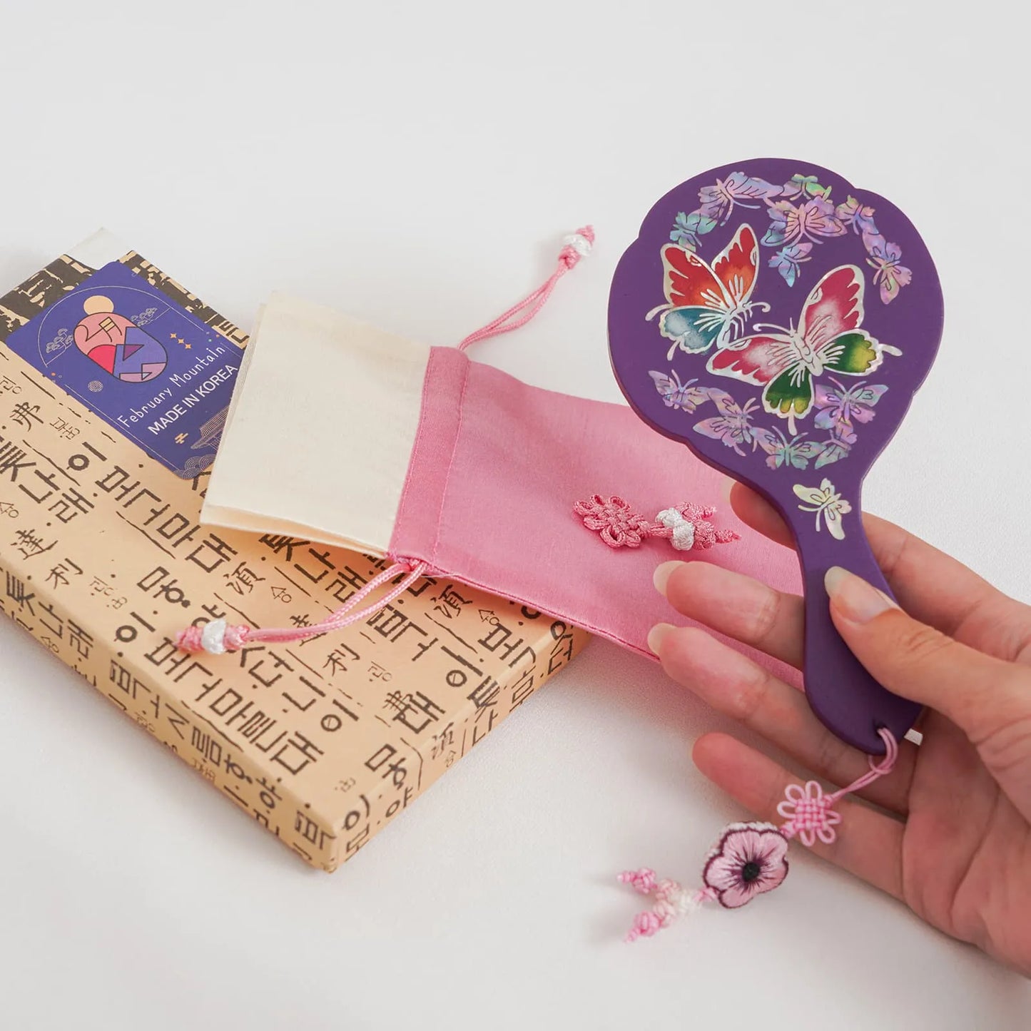 Purple mirror with butterfly pattern, pink pouch, and Korean gift box