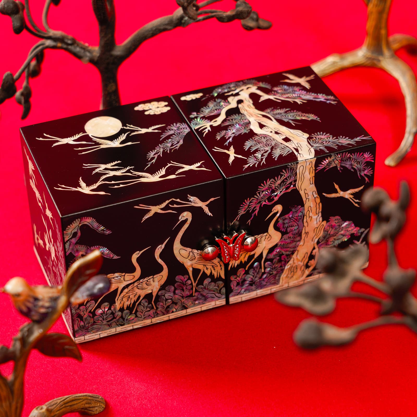 Red lacquer jewelry box with cranes and pine tree inlay, symbolizing longevity and harmony