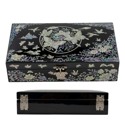 Side-angled view of a black lacquerware box, emphasizing the reflective glossy finish and the distinctive circular butterfly nacre pattern