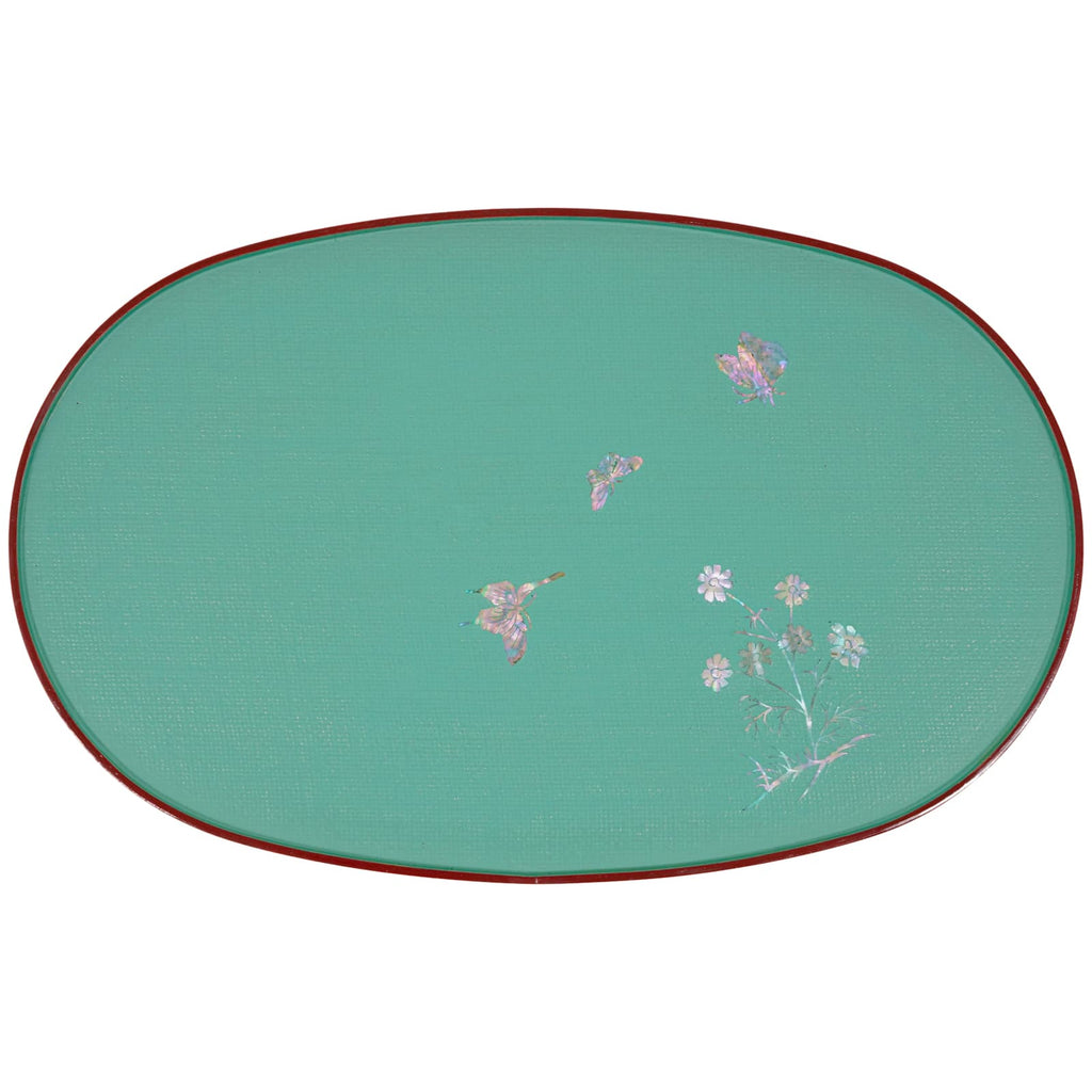 A teal oval tray with a red edge, featuring a delicate mother-of-pearl floral and butterfly inlay on the surface.