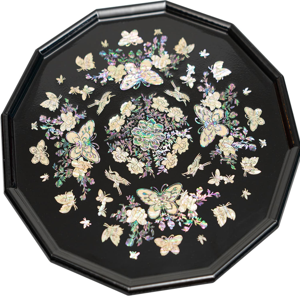 An octagonal tray with mother-of-pearl inlay featuring butterflies and flowers on a black background.