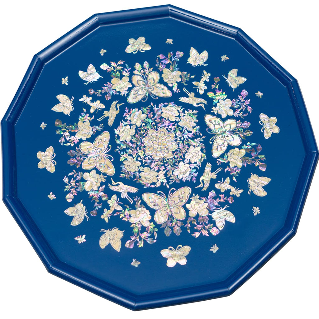 An octagonal tray with mother-of-pearl inlay featuring butterflies and flowers on a blue background.