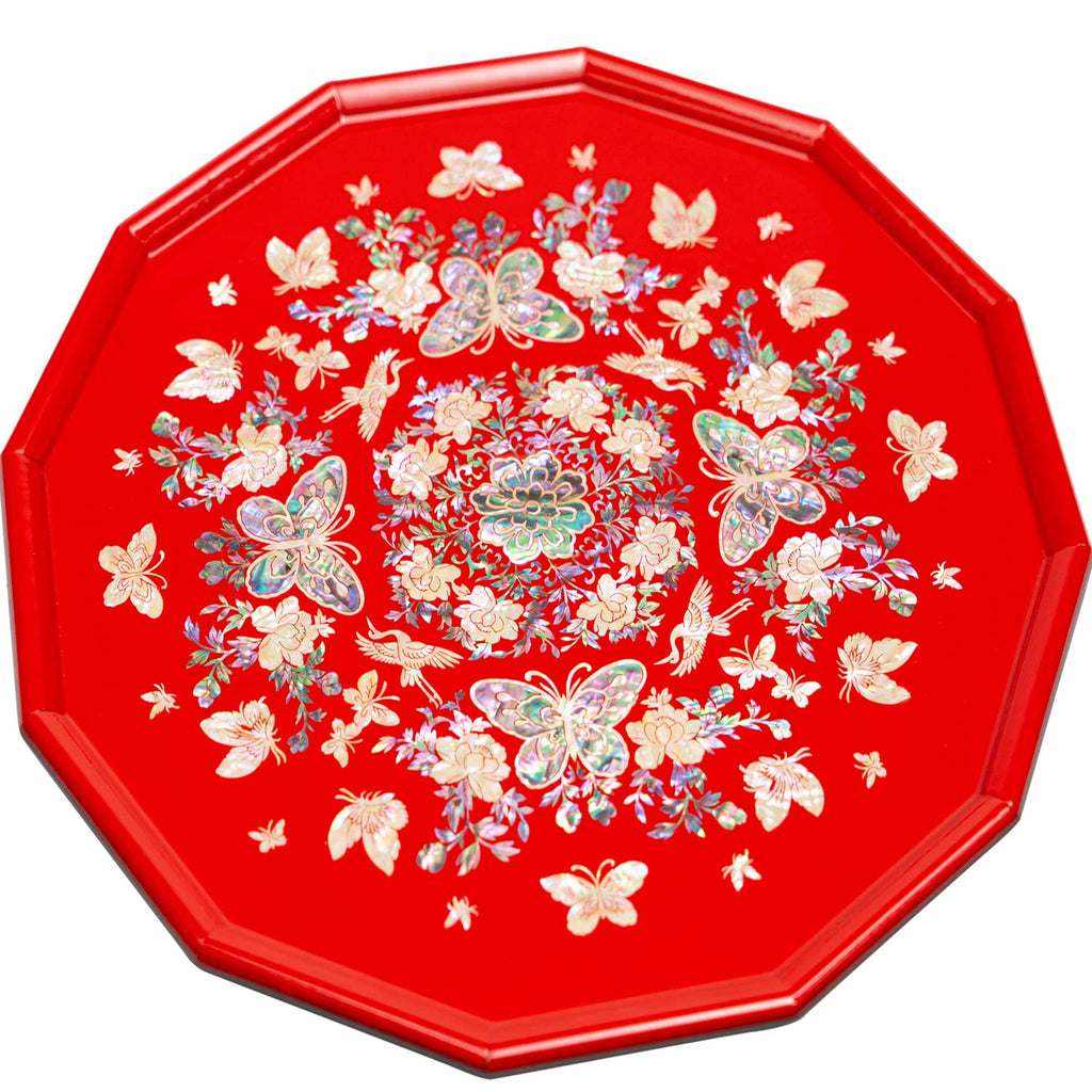 An octagonal tray with mother-of-pearl inlay featuring butterflies and flowers on a red background.
