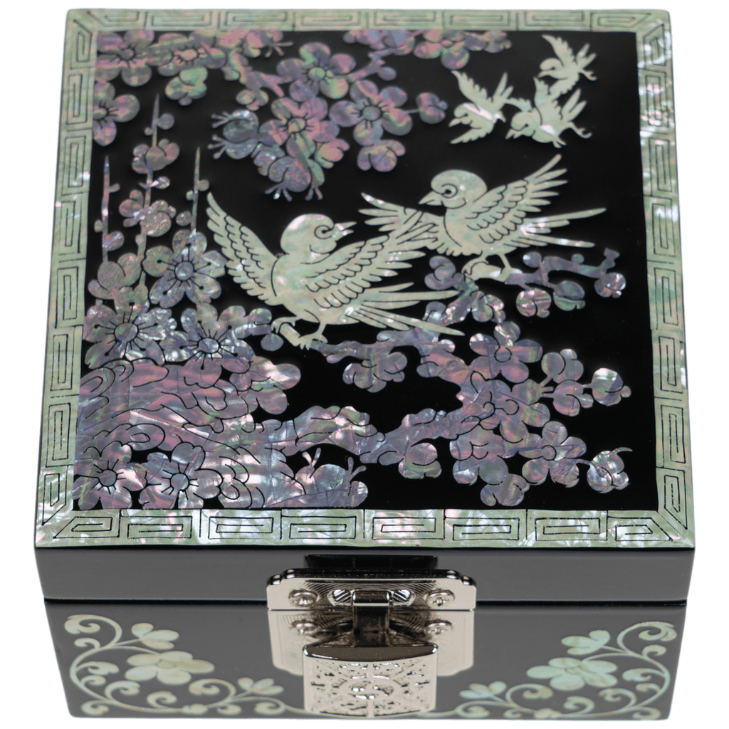 An ornate jewelry box with mother-of-pearl inlay depicting two birds among flowers, bordered by a geometric pattern, complete with a silver front clasp.
