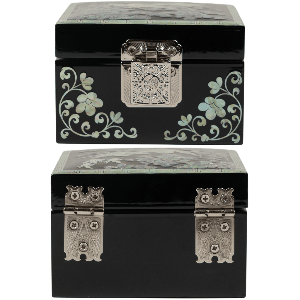 A black jewelry box with silver clasps and mother-of-pearl inlay of floral patterns on its sides and top, displayed in two different views.