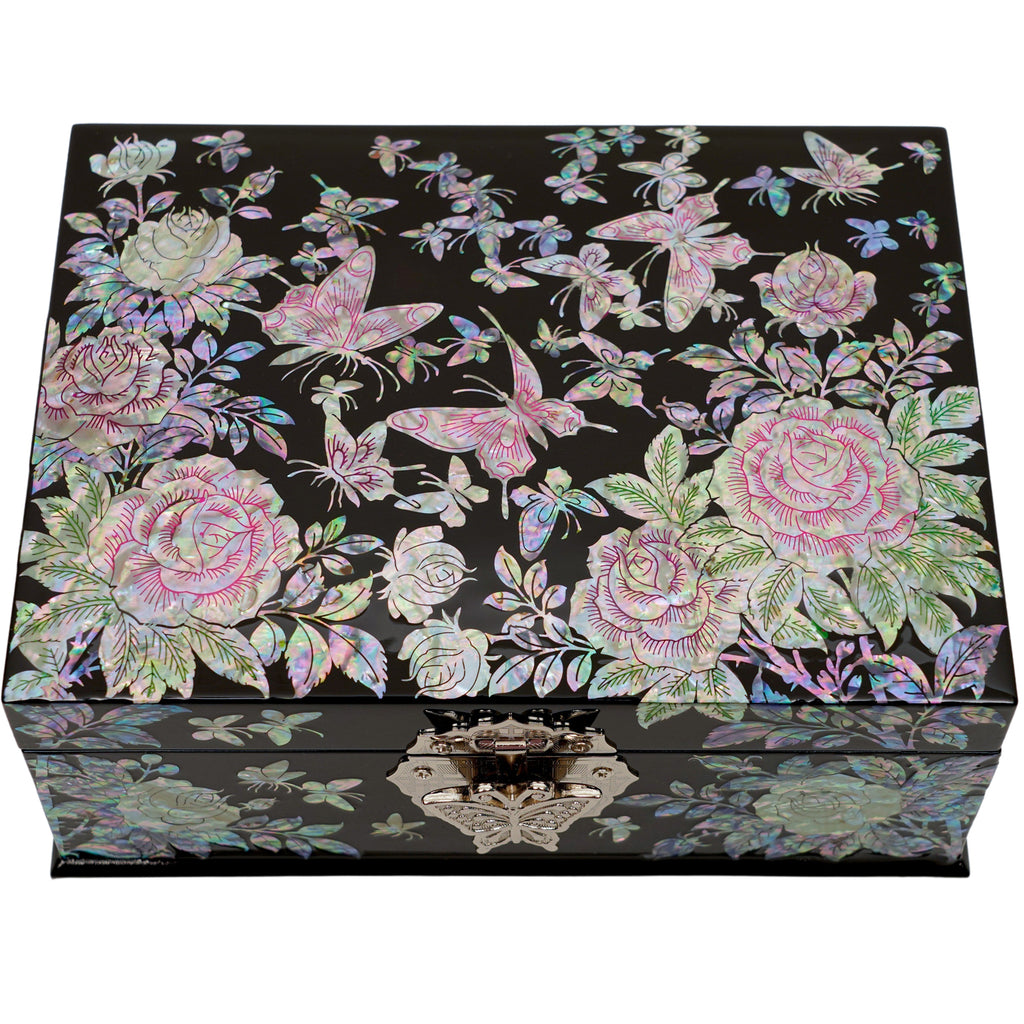  A black lacquered jewelry box with mother of pearl inlay featuring pink roses and butterflies on the lid and a reflective marbled design on the front.