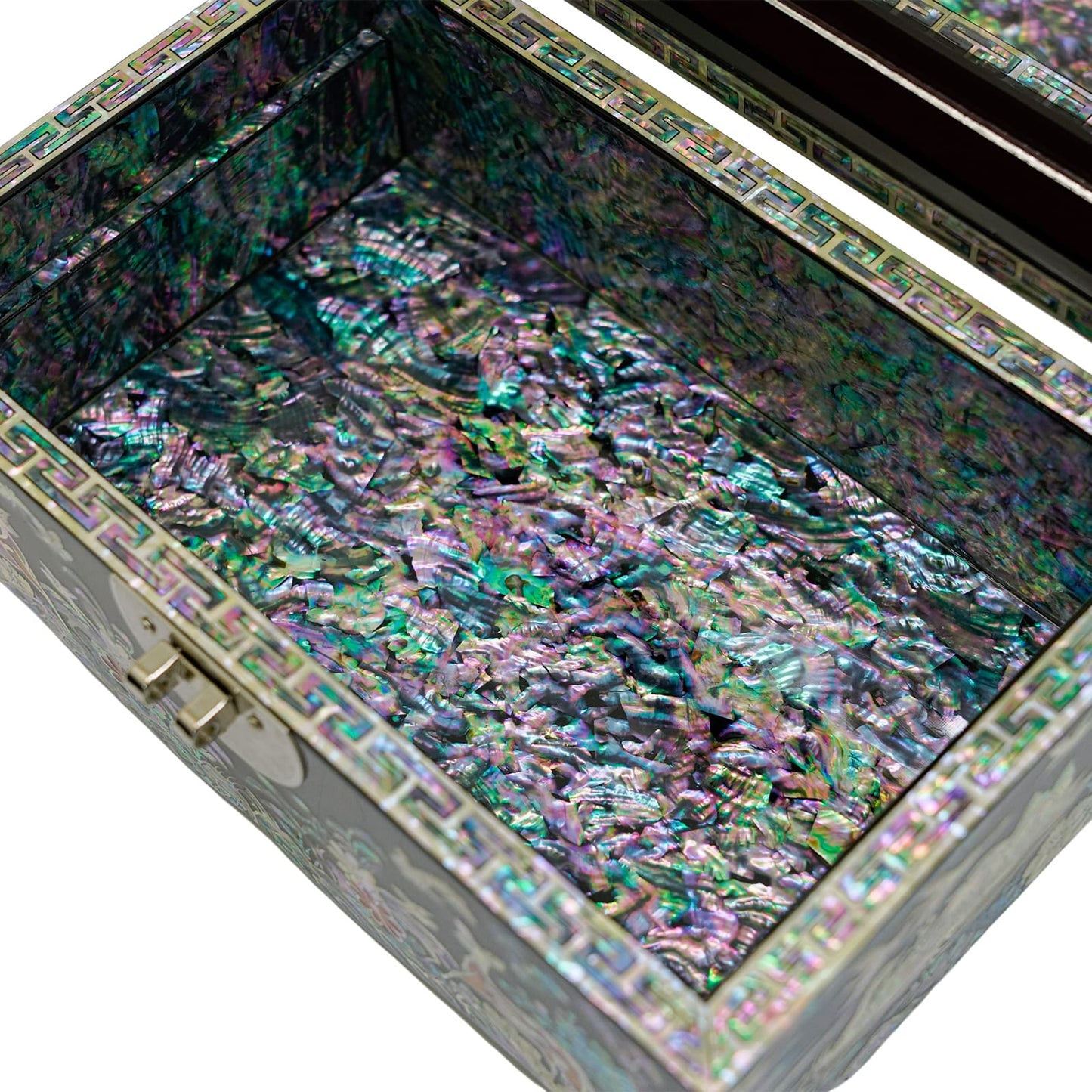 An intricately detailed Mother of Pearl jewelry box open to display a shimmering, iridescent interior, reflecting a spectrum of colors, bordered by a decorative geometric pattern