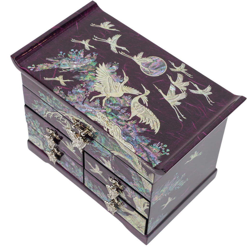 A purple  Korean mother-of-pearl jewelry box adorned with intricate crane and floral inlays, featuring multiple drawers and a hinged lid.