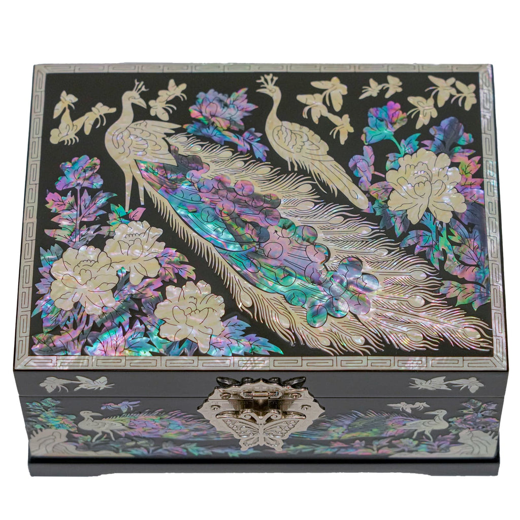  A beautifully crafted Mother of Pearl jewelry box featuring peacock and floral inlays on a geometric-patterned border, closed and viewed from the front.