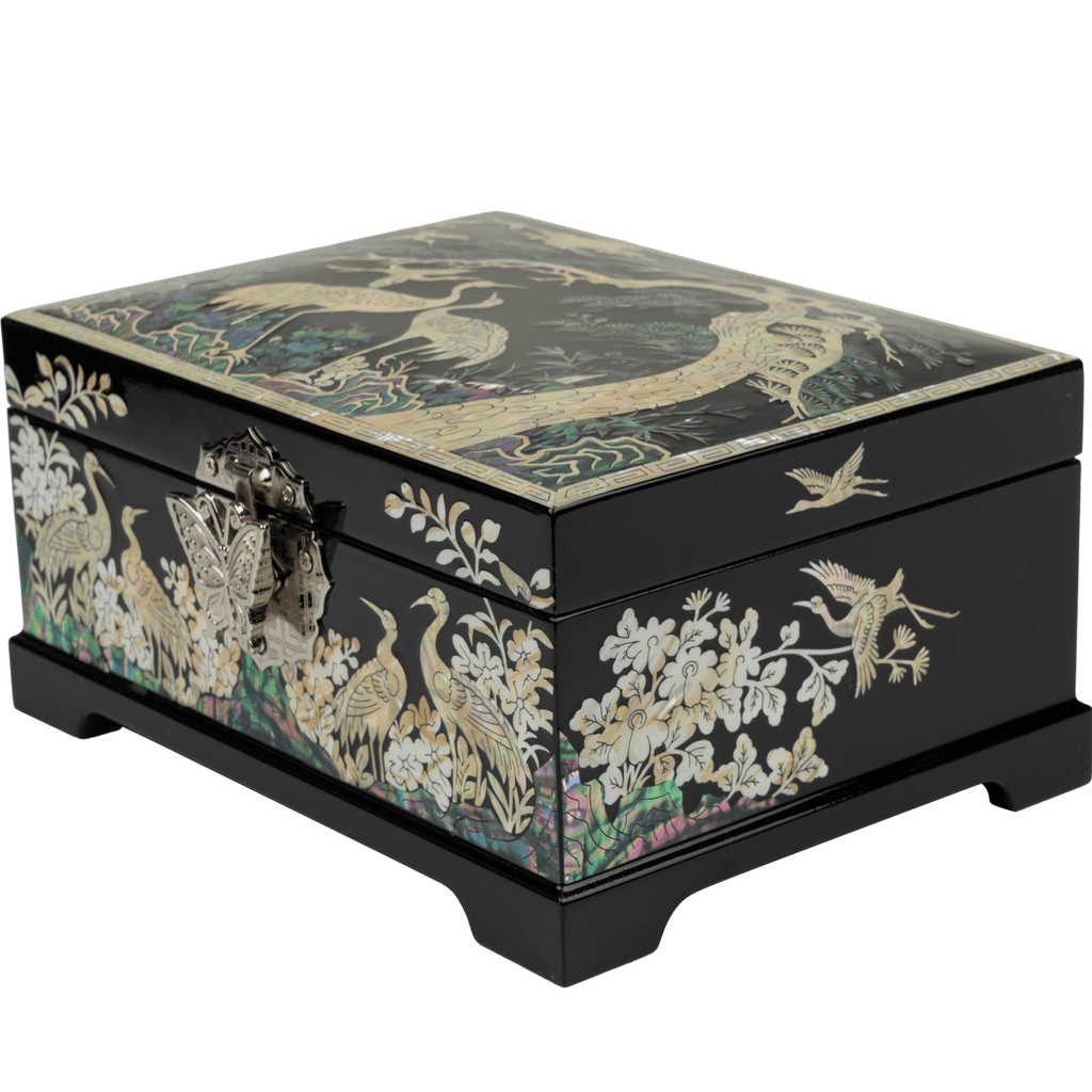 A black, Mother of Pearl jewelry box featuring crane and floral designs with a detailed metal clasp, presented at a side angle.