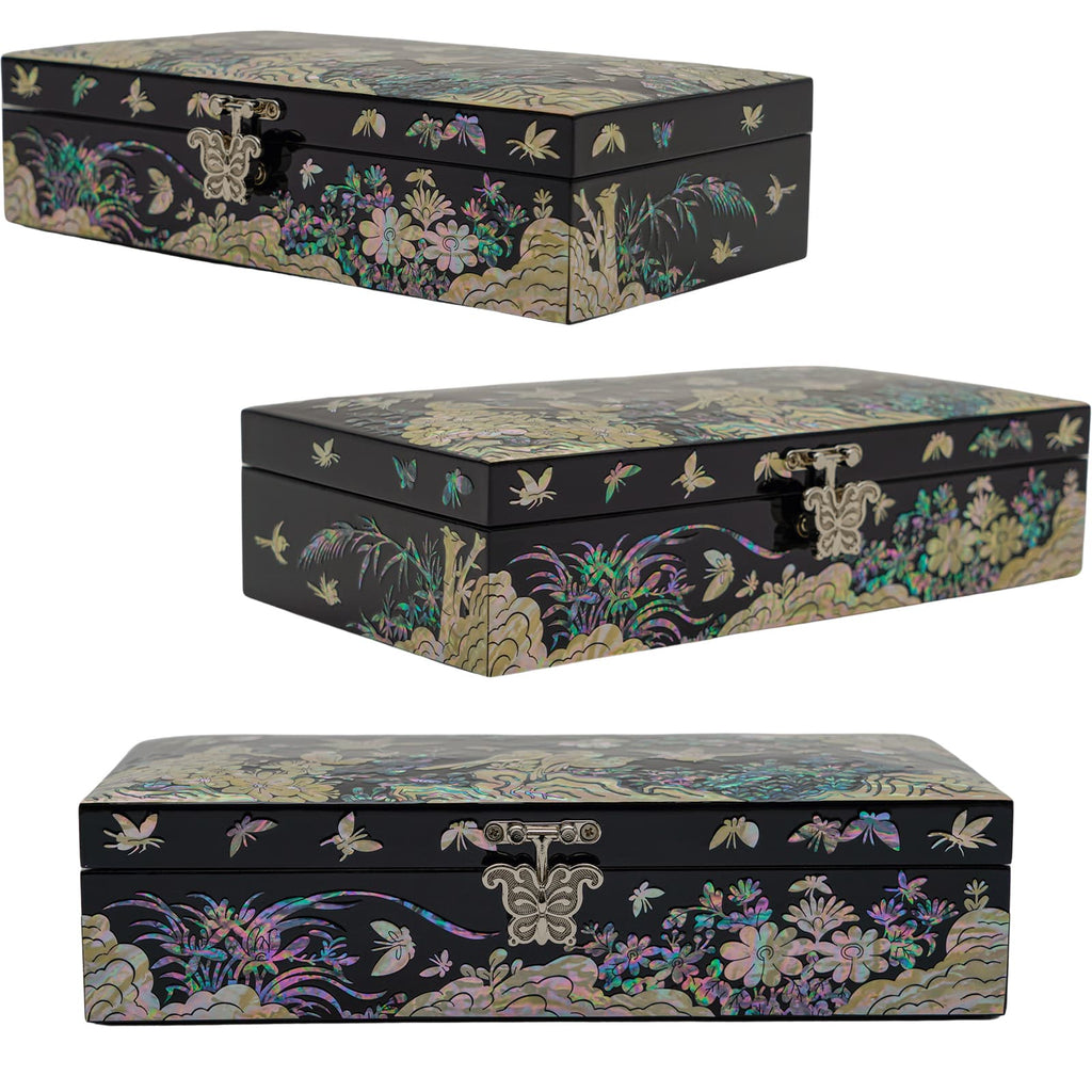 A black, rectangular jewelry box with mother-of-pearl inlay showcasing florals and butterflies, with a silver butterfly clasp, presents a classic and intricate design.
