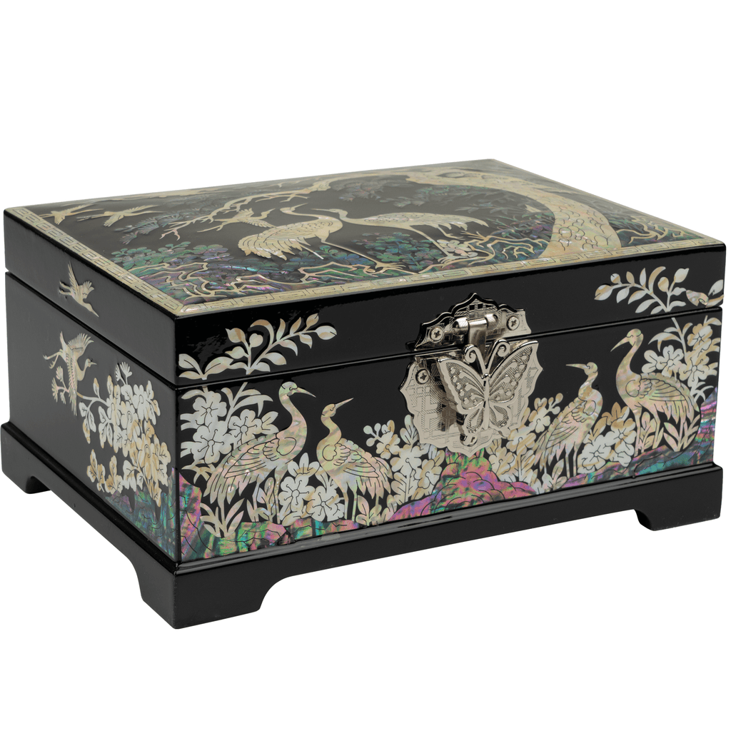 A black jewelry box with Mother of Pearl inlay depicting cranes and flowers, viewed at a 45-degree angle, showcasing the intricate clasp.