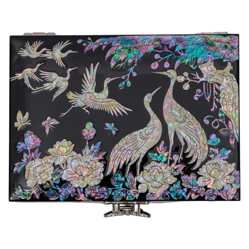 A black lacquer box with mother-of-pearl inlay featuring cranes and flowers, reflecting a traditional Asian art style.