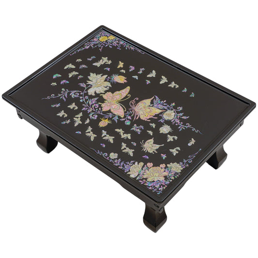 A black lacquered table with intricate mother-of-pearl inlay of butterflies and flowers on the surface.