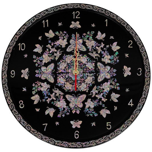 A circular wall clock adorned with iridescent Mother of Pearl patterns featuring butterflies, flowers, and other delicate designs on a black background. The clock hands are centered with numbered hours around the edge.