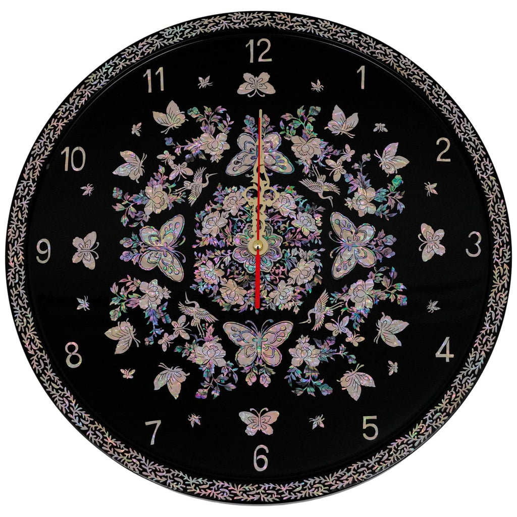 A circular wall clock adorned with iridescent Mother of Pearl patterns featuring butterflies, flowers, and other delicate designs on a black background. The clock hands are centered with numbered hours around the edge.