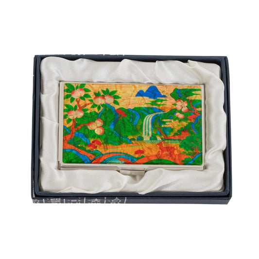 An open dark blue box with white text holds a colorful rectangular item decorated with flowers and birds.