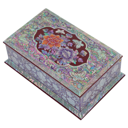 Angled view of mother-of-pearl peony and butterfly inlay on burgundy box lid