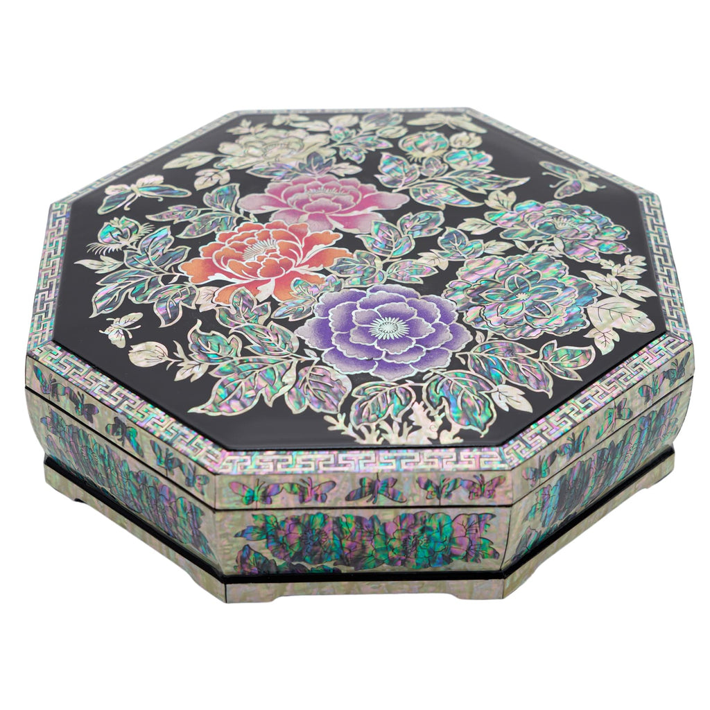 An octagonal black box with a lid featuring vibrant traditional Korean floral patterns and a complex geometric border.