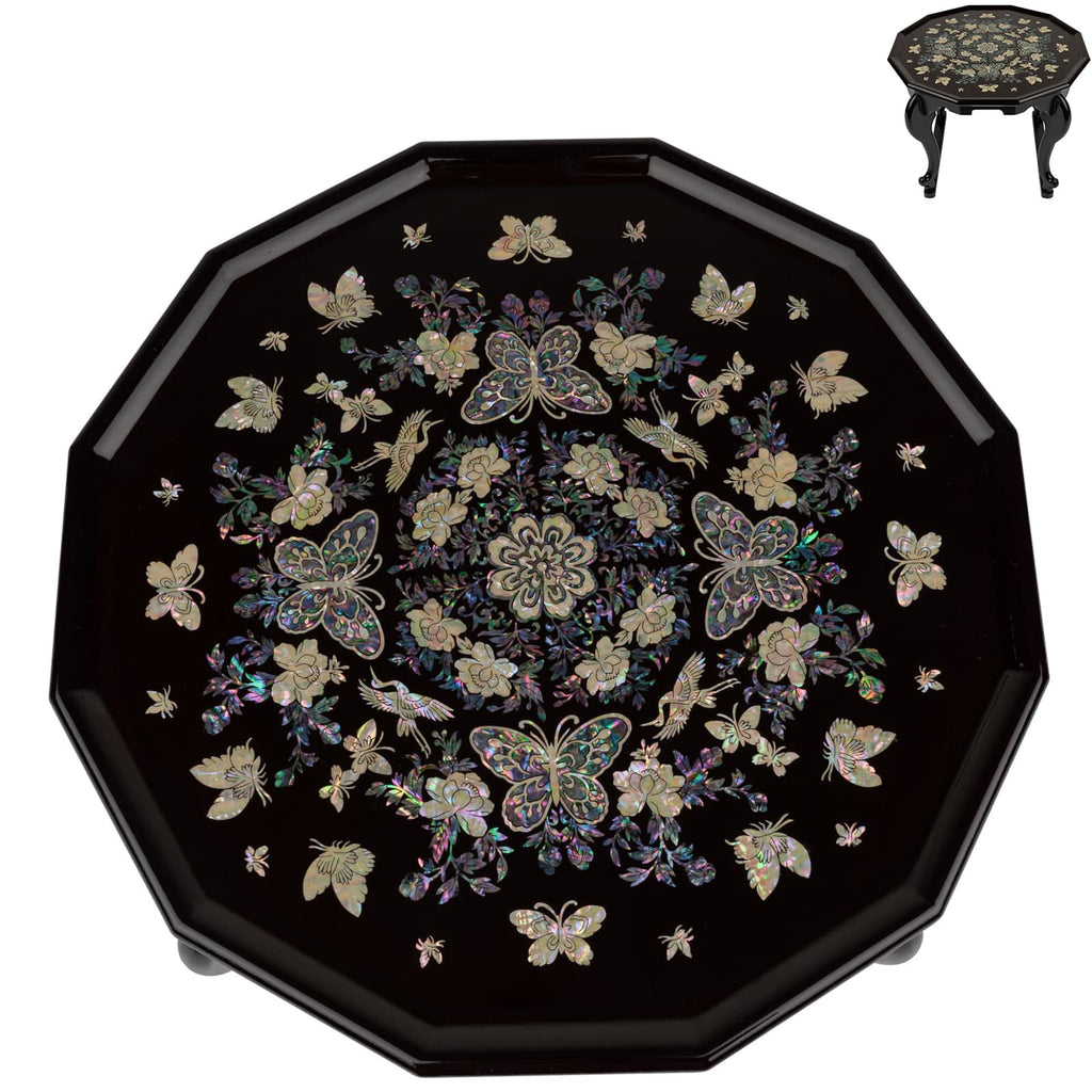 An octagonal black lacquer tea table with a detailed mother-of-pearl inlay featuring butterflies and flowers, displayed on a stand with a similar design.