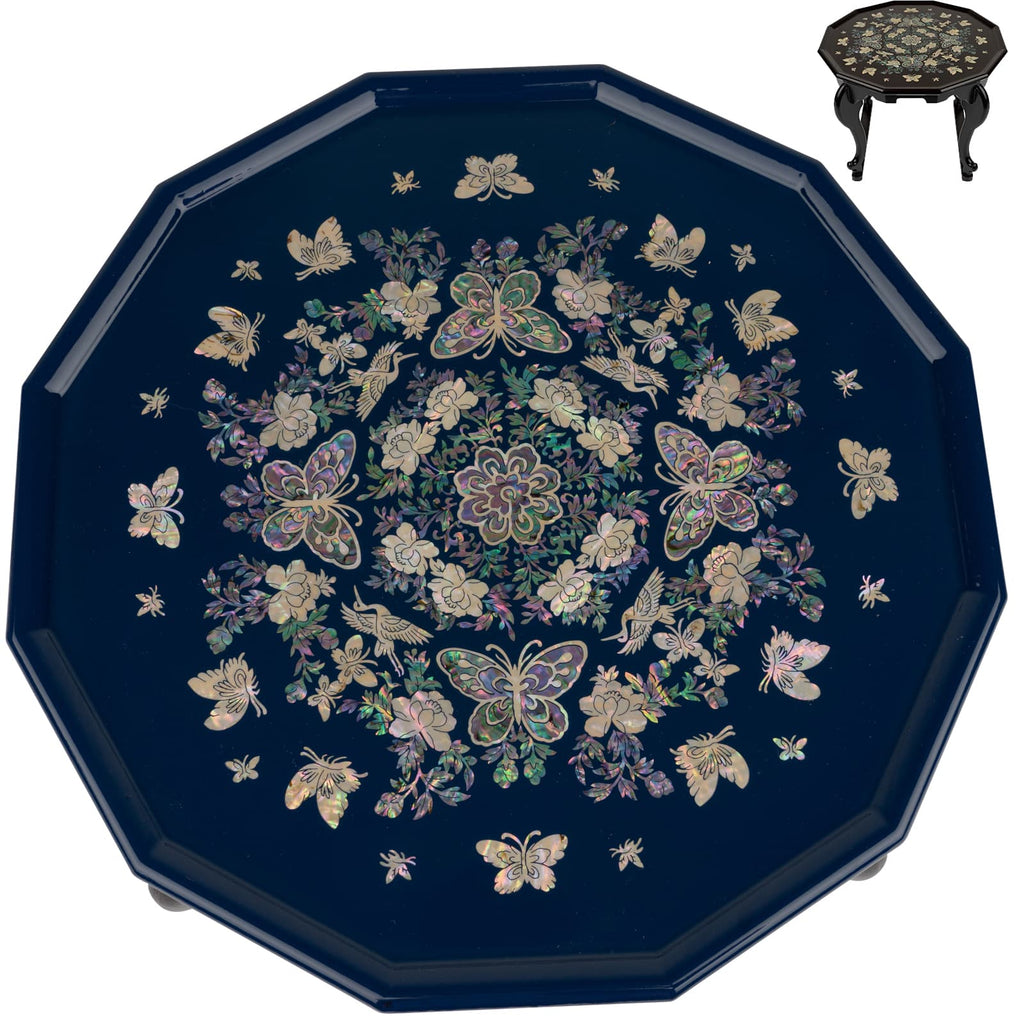 An octagonal blue lacquer tea table with a detailed mother-of-pearl inlay featuring butterflies and flowers, displayed on a stand with a similar design.