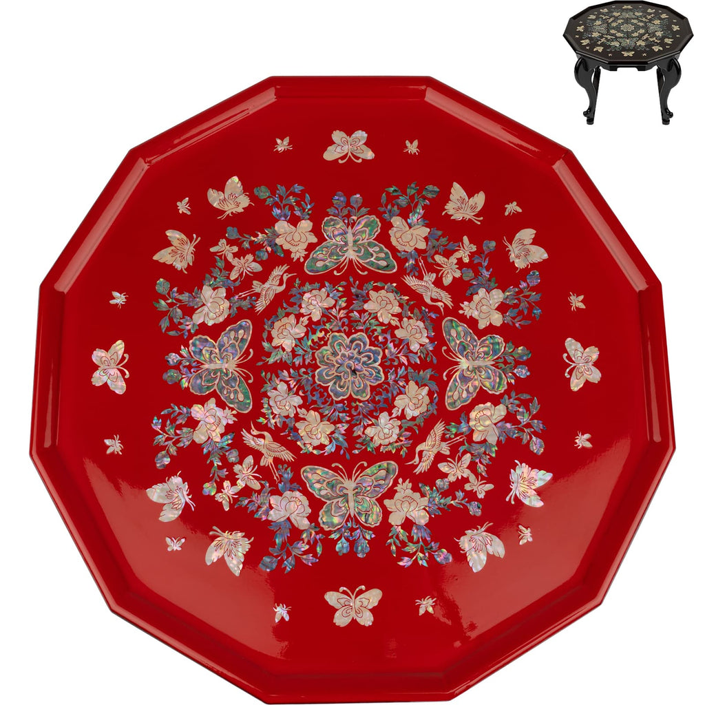 An octagonal red lacquer tea table with a detailed mother-of-pearl inlay featuring butterflies and flowers, displayed on a stand with a similar design.
