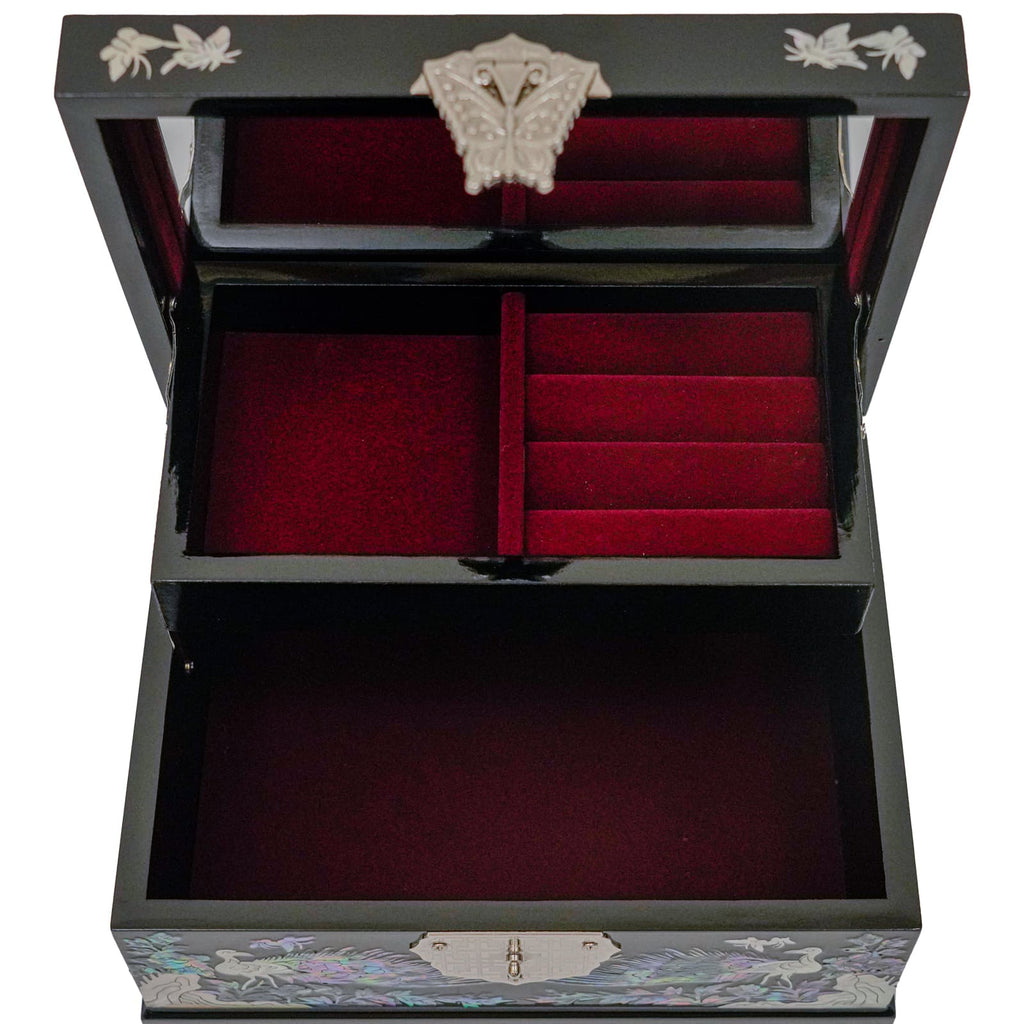  An open black jewelry box with Mother of Pearl inlay, featuring a red velvet interior and multiple compartments for organizing jewelry.