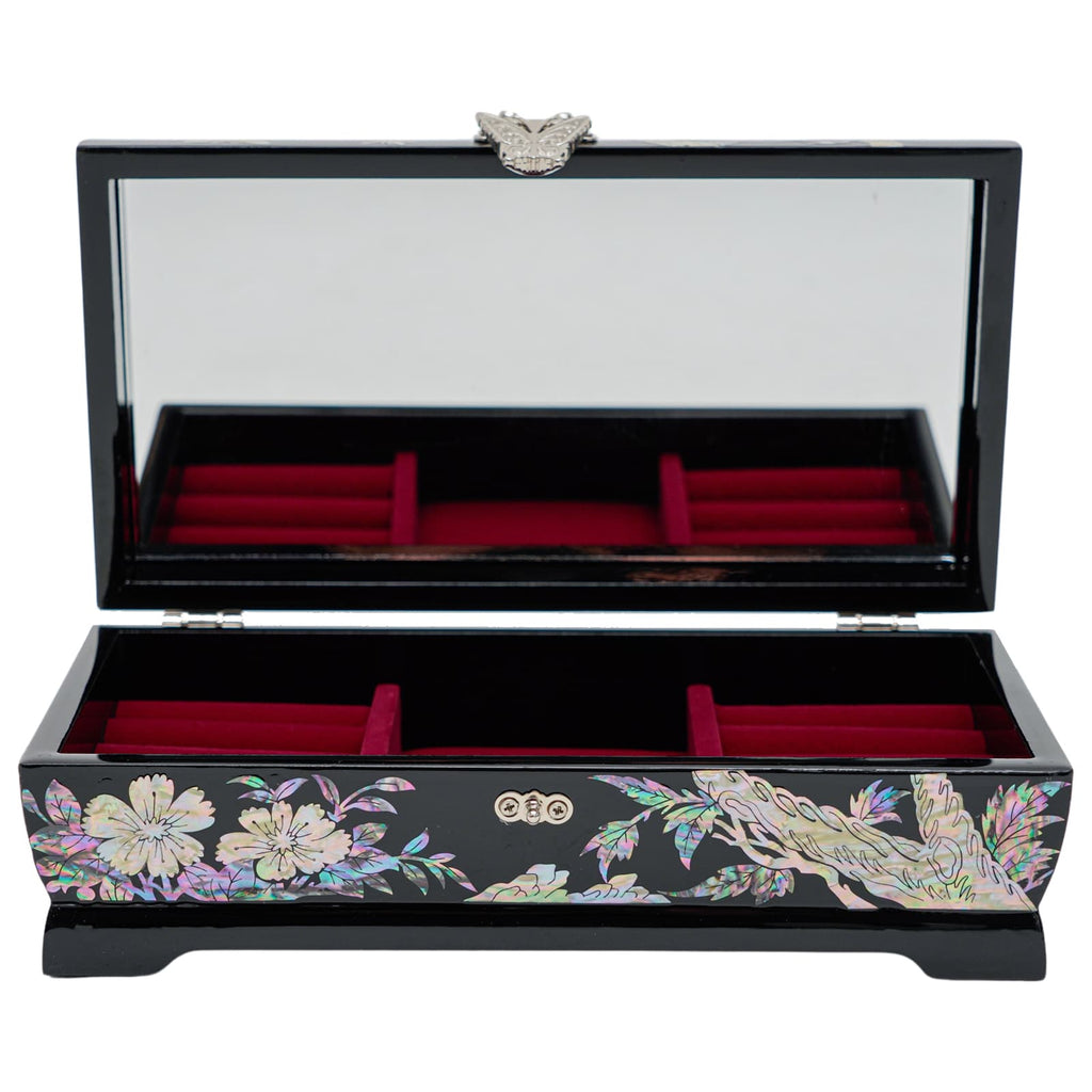 An open black jewelry box with a mirror, red velvet interior, and a detailed mother-of-pearl inlay featuring flowers on the exterior.