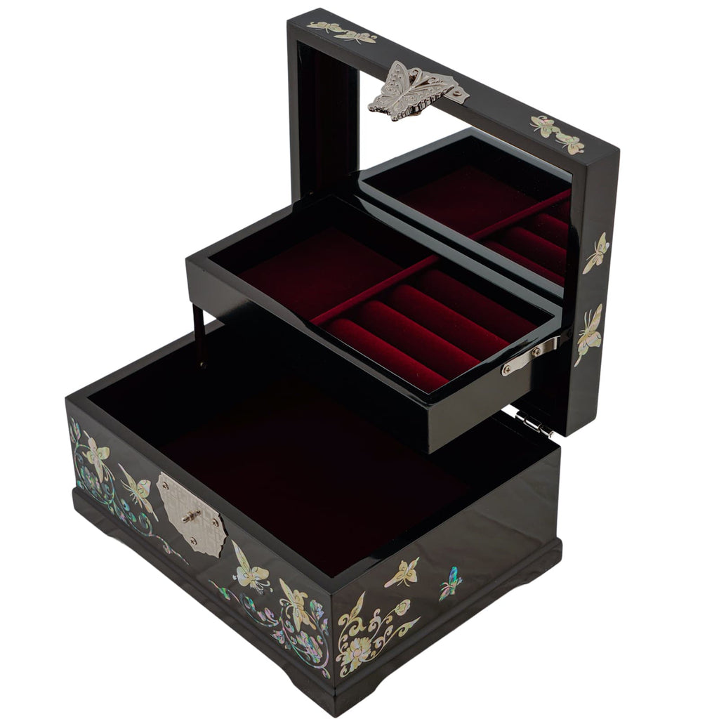 An open black jewelry box with mother-of-pearl inlay and velvet-lined trays, featuring a butterfly detail on the mirror.