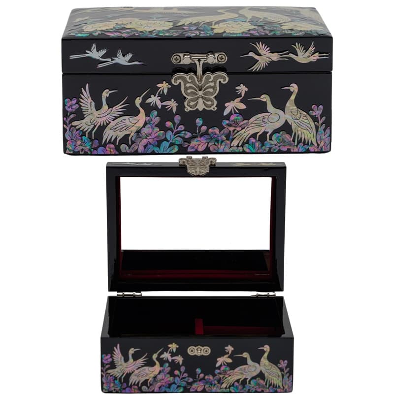 An open black lacquer box with mother-of-pearl crane and floral inlay, revealing a red interior, combines elegance with traditional Asian design.