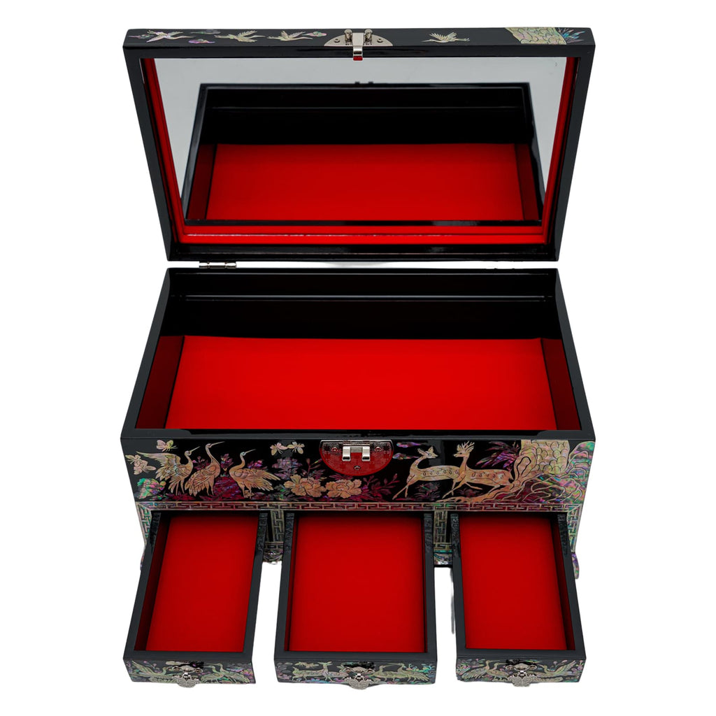An open lacquered jewelry box with mother-of-pearl inlay detailing, featuring a large upper compartment and three drawers, all lined with red velvet, perfect for storing various pieces of jewelry.