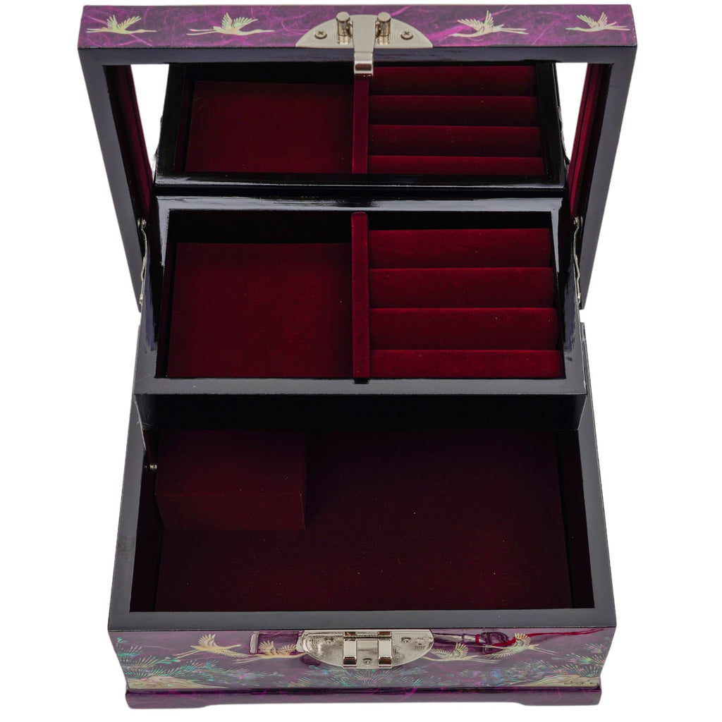 An open mother-of-pearl inlaid jewelry box with multiple red velvet-lined compartments, a crane and floral pattern on a purple background, and metallic hinges and latch.