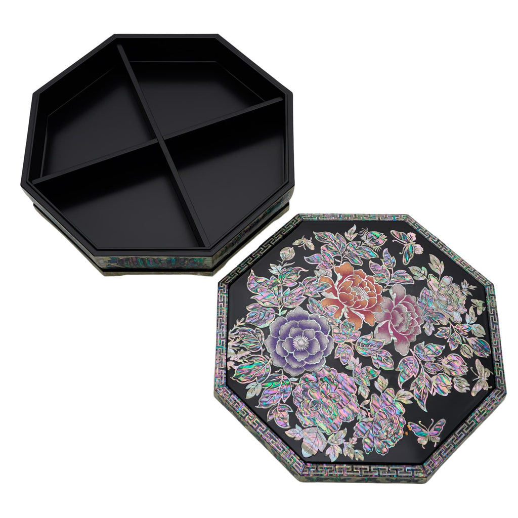 An open octagonal black box with a traditional Korean floral design on the lid, featuring a colorful and intricate geometric border.