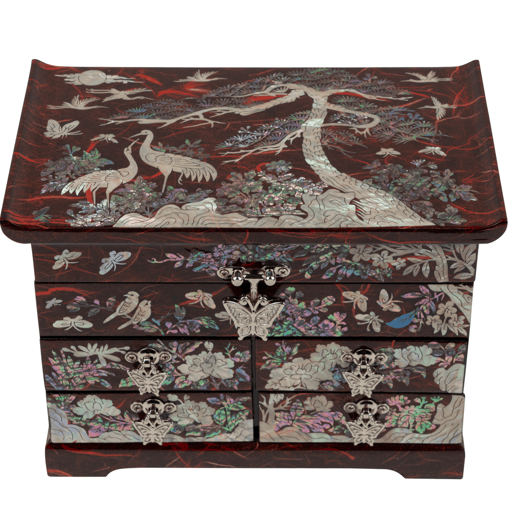 A red jewelry box with mother-of-pearl inlay and crane designs.