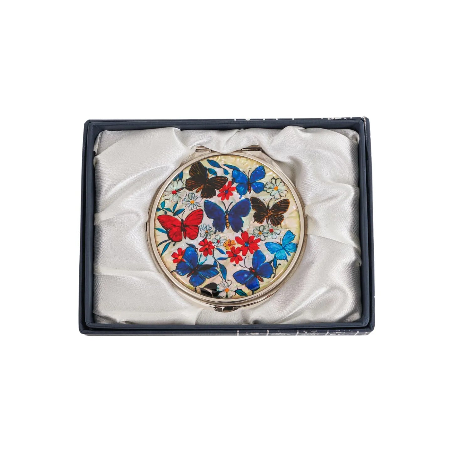 A round compact mirror with colorful butterfly and flower designs, placed inside a satin-lined gift box