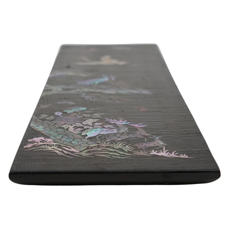 A wooden tray wrapped in rectangular hemp with a mother-of-pearl deer design, shown from an angle.