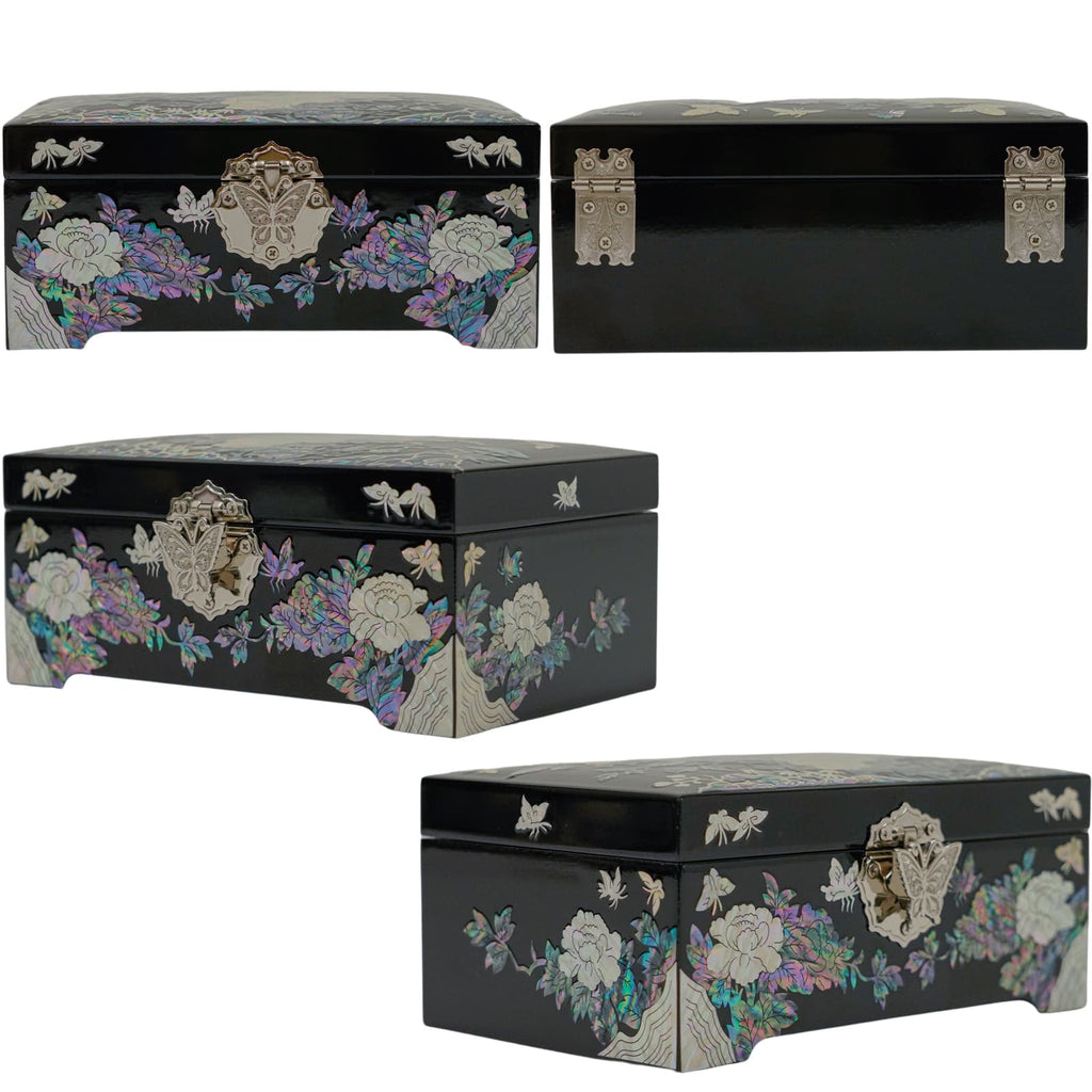A black jewelry box with mother-of-pearl inlay, featuring floral and butterfly designs, and distinct metal clasp and corner details.