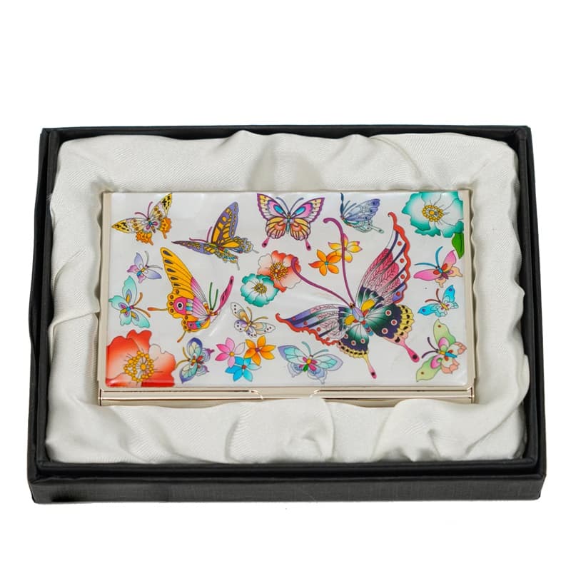 A card case with a vivid butterfly and floral design on a white background, presented in a black box with a soft, white satin lining.