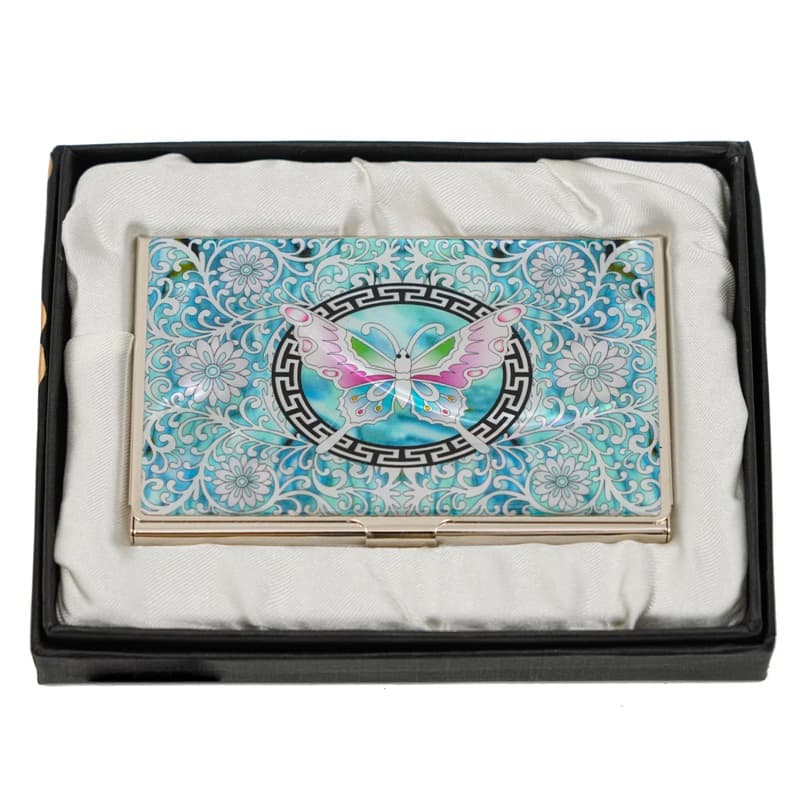 An ornate mother-of-pearl business card holder with a blue background and a central butterfly motif, encased in a protective black box with a white cloth interior.