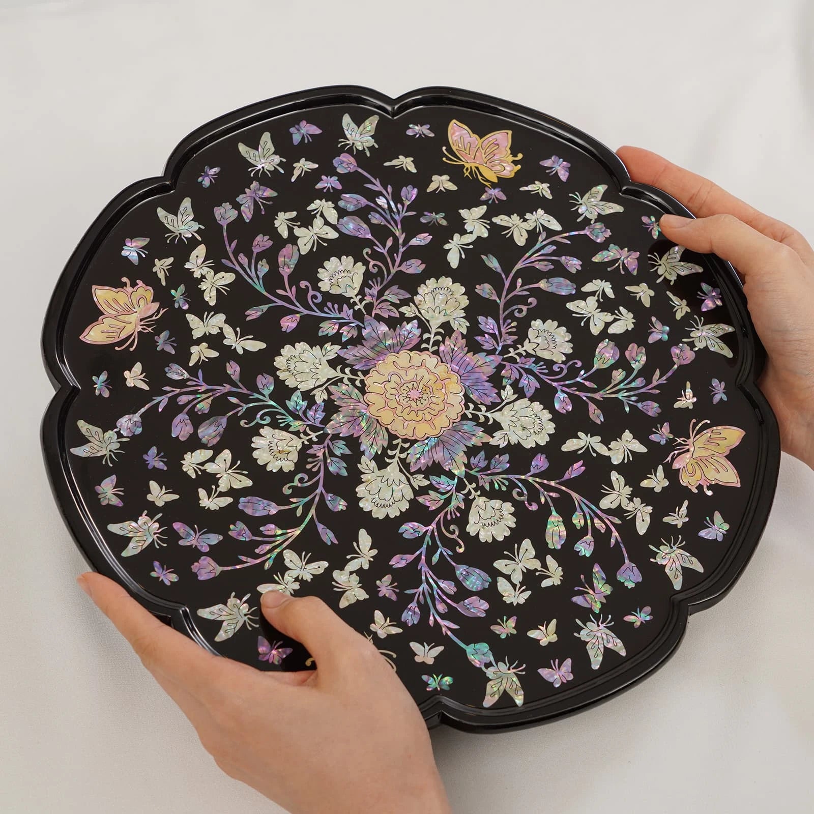 Black Korean mother of pearl serving tray with scalloped edge and floral butterfly inlay pattern, handcrafted lacquer finish.